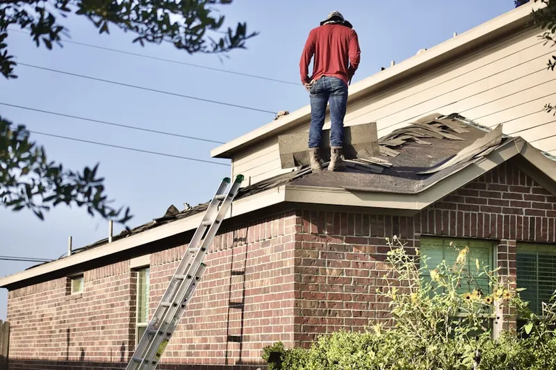 Professional roofer working on a residential roof in Touchet